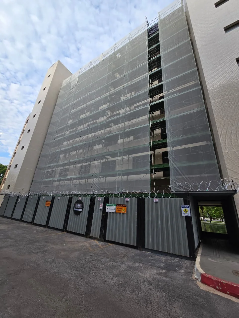 Andaimes fachadeiros com tela de proteção no Residencial Evolution